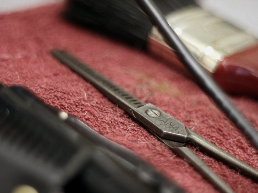 Clippers, scissors and combs laid out on the counter before opening.